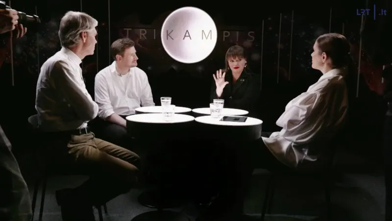 Laidos „Trikampis“ studija: Jonas Dagys, Aivaras Vilutis, aš ir Goda Raibytė prie šviečiančių stalų, už mūsų – laidos pavadinimas